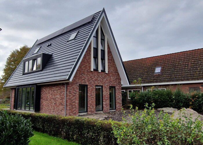 Moderne woning met rode bakstenen en blauwe dakpannen