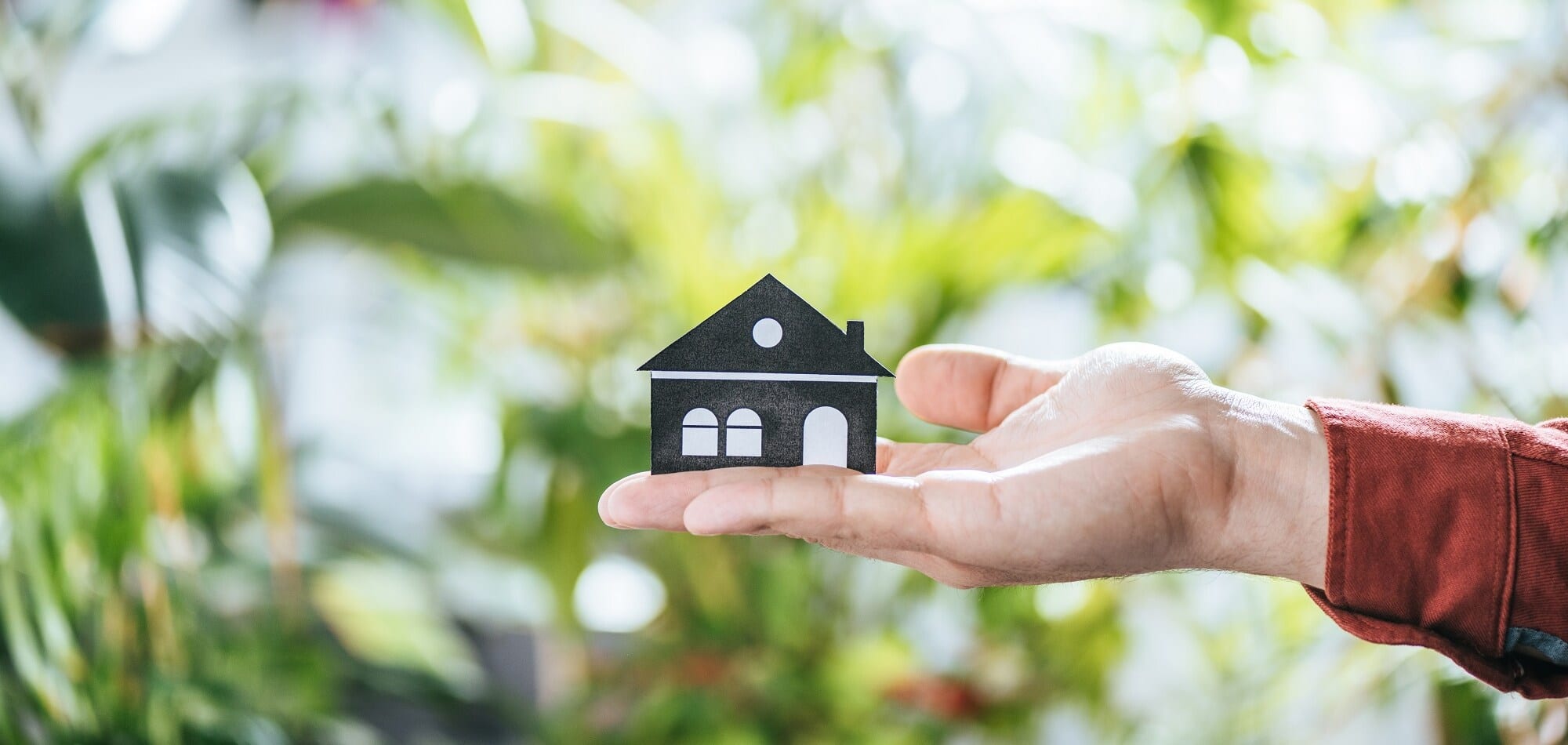 cropped view of mah holding paper house, energy efficiency at home concept